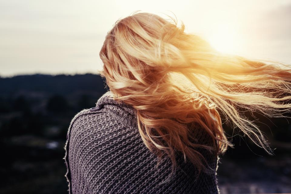 cabelos iluminados da mulher que olha o horizonte