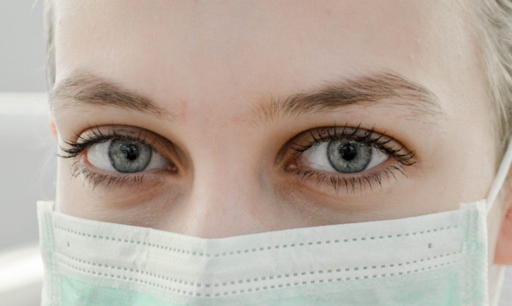 mulher com mascara contempla o Deus da esperança